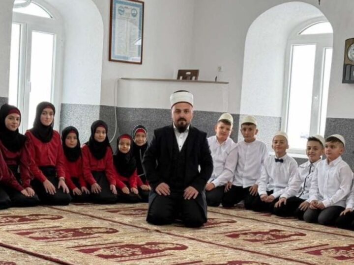 Me plisa në kokë dhe të veshur kuq e zi në Xhami